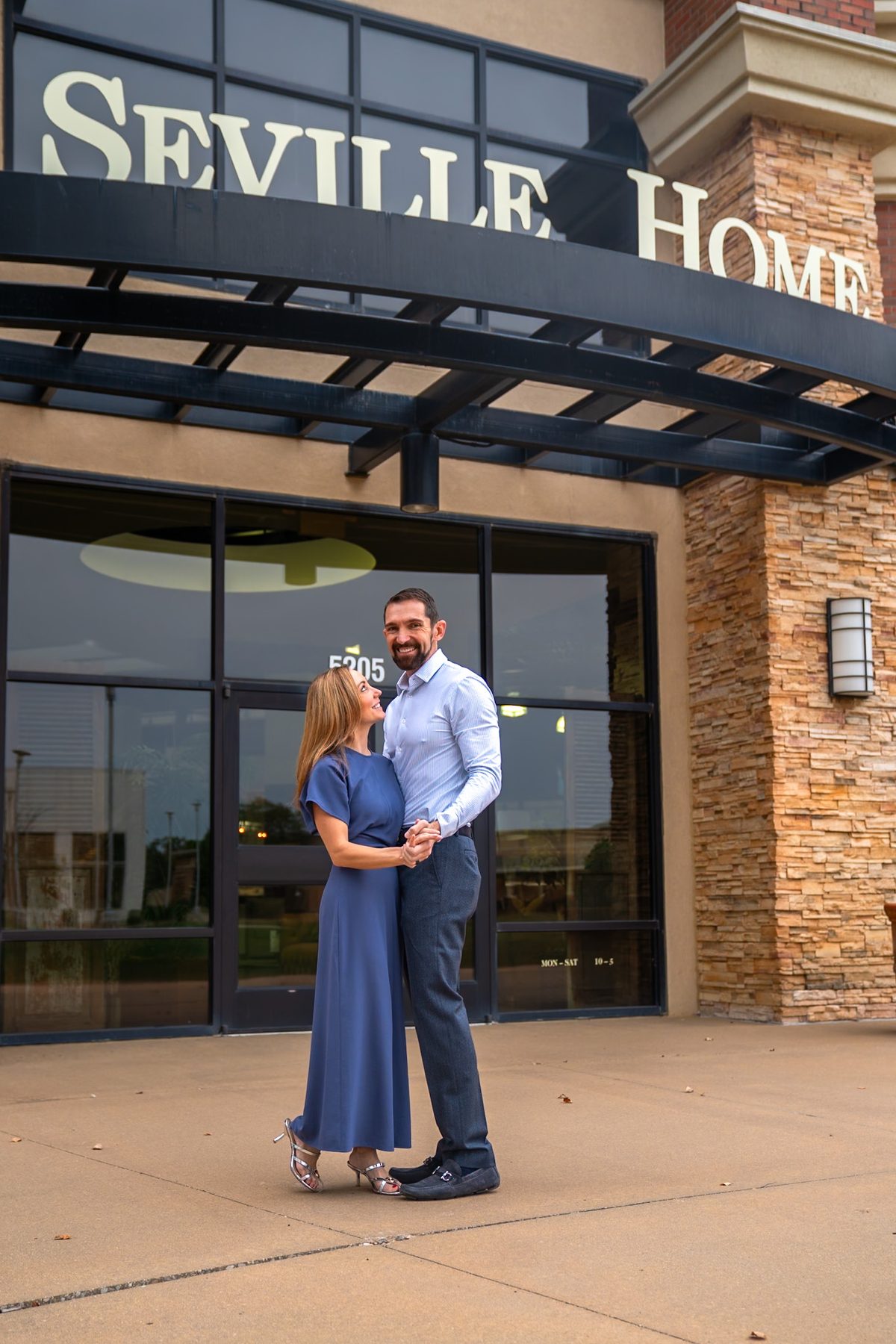 Chastin and Phil Reynolds beneath the Seville Home sign at the Leawood storefront